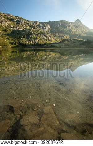 Scenic Bettmer Lake Near Fiesch In Wallis, Switzerland. Reflection On The Lake At Sunrise