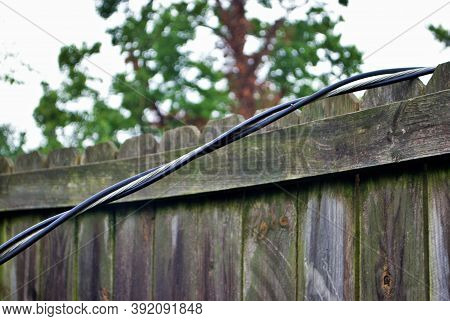 Dangerous Live Downed Power Line Draped Across Fence