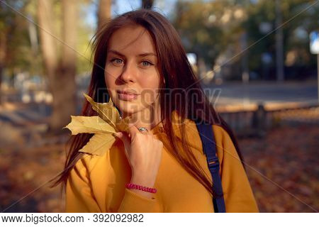 Beautiful Caucasian Young Woman Walking And Having Fun Outdoors In Autumn Time. Bright Yeallow Color