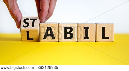 Hand Turns A Cube And Changes The German Word 'labil' - Unstable In English To 'stabil' - Stable In 