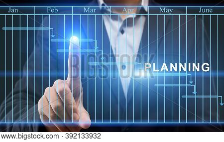 Businessman Using Digital Interface With Gantt Chart For Business Planning, Updating Tasks And Annua
