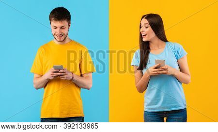 Portrait Of Smiling Curious Woman Using Smartphone, Looking And Peeking At Her Boyfriends Phone. Guy