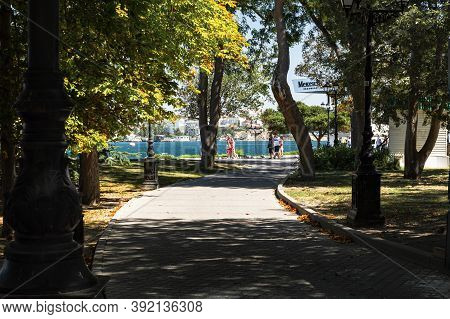 Sevastopol Central Alley Of The City On August 13, 2020. Random Shots Of Tourists Walking. Green Bri