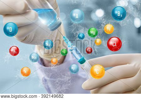Vitamin Complex Injection Concepts. Syringe In Hand Against The Background Of Vitamins.
