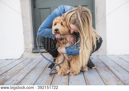 Labradoodle Dog And Woman Outside On Balcony