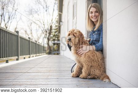 Labradoodle Dog And Woman Outside On Balcony