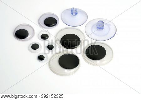 Plastic Eyes For Toys On A White Background. Elements From Plastic For Sewing Toys. And Two Suction 