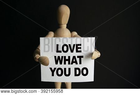 The Wooden Man Holds A White Sign With The Text Love What You Do In His Hands. The Content Of The Le
