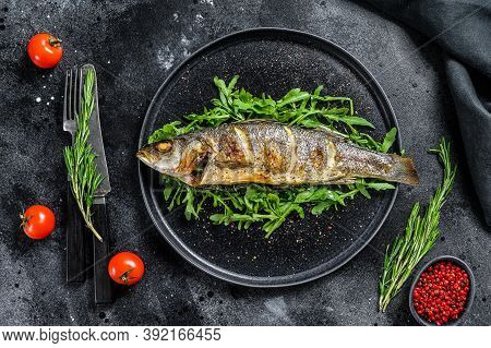 Baked Sea Bass Fish With Arugula, Grilled Seabass. Black Background. Top View