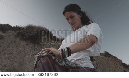 Young Caucasian Brunette Woman Doing Youga On The Sandy Beach In The Morning. High Quality Photo