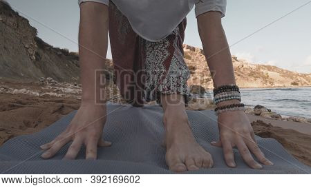 Young Caucasian Brunette Woman Doing Youga On The Sandy Beach In The Morning. High Quality Photo
