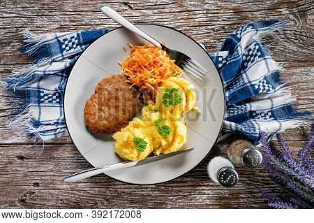 Homemade Minced Meat Cutlet Served With Mashed Potatoes And Carrot Salad.