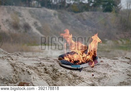 Burning Sports Sneakers Or Gym Shoes On Fire Stand On Sandy Beach Coast. Athlete Burned Out. Physica