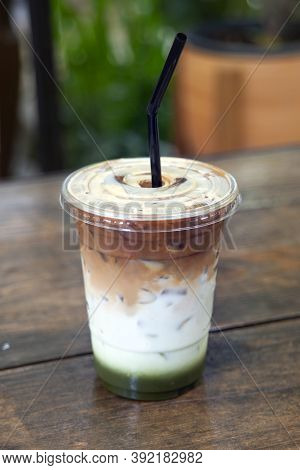Healthy Drink Mixed With Green Tea And Milk In Layers Of Color On Wooden Table.