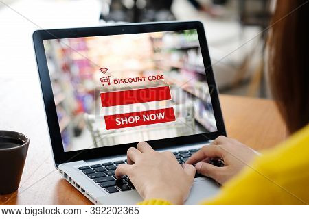 Hand Typing Discount Coupon Code On Laptop Computer Screen To Get The Shopping Online Sale Promotion