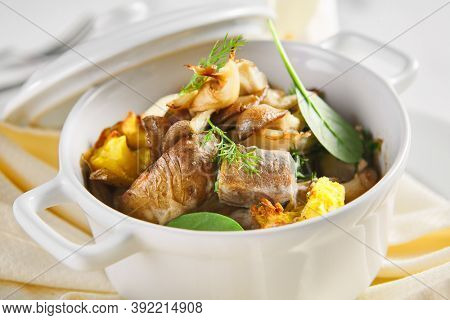 Beef tongue Pot Roast with mushroom and potato. White ceramic pot. Restaurant gourmet food