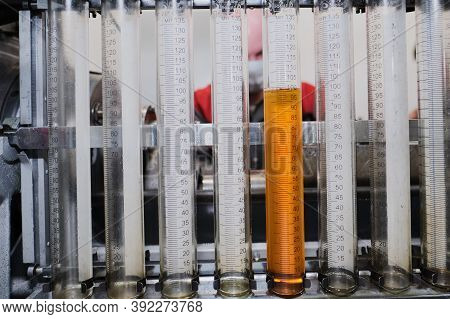 Test Bench For Checking The Injection Pump Of An Industrial Diesel Engine. Glass Flasks With Diesel