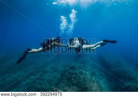 August 20, 2020. Anapa, Russia. Couple Of Scuba Divers Glides Underwater In Transparent Blue Sea. Sc