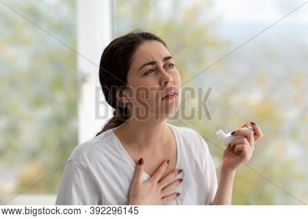 Allergic Asthma. Portrait Of A Woman Holding An Inhaler With Medicine In Her Hand And Clutching Her 