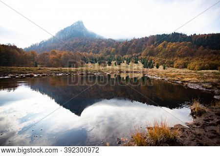 Scenic autumn view of small lake at Roosterâs Ridge, Gutaiului Mountains, Romania.