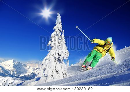 Skier skiing downhill in high mountains