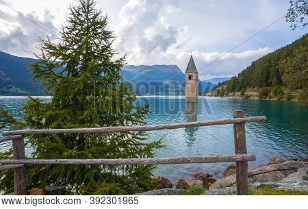 The Bell Tower Of The Sunken Church In Curon, Resia Lake, Bolzano Province, South Tyrol, Italy.