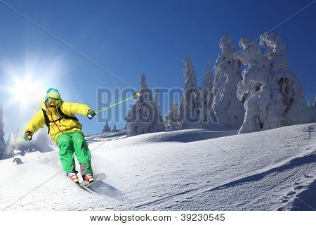 Skier skiing downhill in high mountains