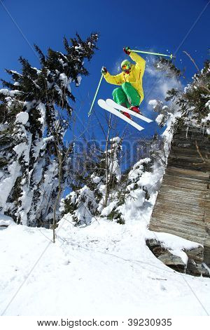 Skier jumping against blue sky from the rock