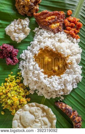 Homemade fish thali meal served at bannana leaf in Kerala state, India. Overhead view