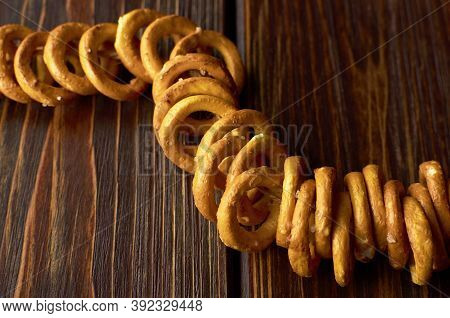 Small Wheat Bagels With Salt On A Rope On Dark Wooden Table. Traditional Russian Food.