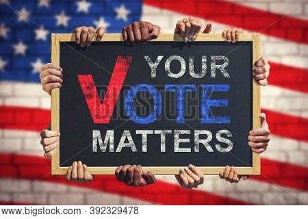 A Lot Of Hand Are Holding A Banner With Text Your Vote Matters On Background Of American Flag. Your 