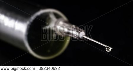 Medical Syringe, Injection With Focus On The Needle, Falling Drop, Dripping Liquid, Macro Photograph