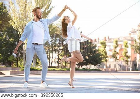 Lovely Young Couple Dancing Together Outdoors On Sunny Day