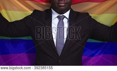 African American Black Man In Elegant Suit Holding Rainbow Flag. High Quality Photo
