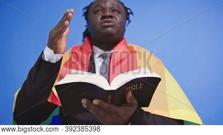 African American Black Man With Elegant Suit Rainbow Flag Covering His Shoulders Holding Holy Bible 