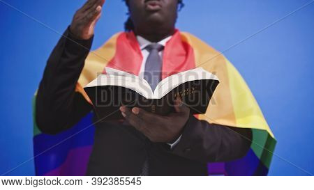 African American Black Man With Elegant Suit Rainbow Flag Covering His Shoulders Holding Holy Bible 