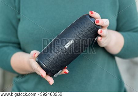 Young Girl Holds Nomi Black Portable Usb Speaker By Nomi Electronics Company. New Outstanding Mobile