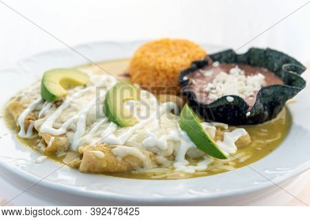 Enchiladas Suizas Served With Rice And Tortilla Chip Bowl Refried Beans Looks And Tastes Appealing.