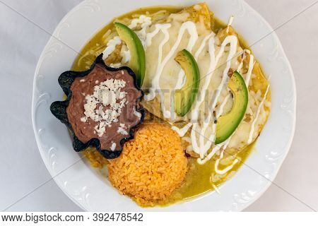 Overhead View Of Enchiladas Suizas Served With Rice And Tortilla Chip Bowl Refried Beans Looks And T