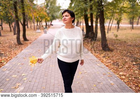Beautiful Caucasian Woman Walking And Having Fun Outdoors In Autumn Time. Bright Yeallow Colors