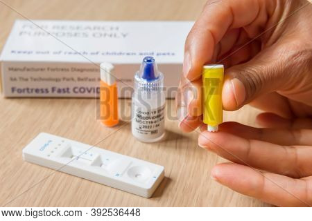 Buckingham, Uk - October 30, 2020. Indian Woman Self-testing With A Coronavirus Antibody Finger-pric