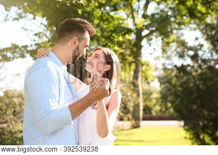 Lovely Young Couple Dancing Together In Park On Sunny Day