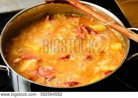 Preparing Tasty Homemade Czech Cabbage Soup Zelnacka With Smoked Bacon And Potatoes In Cooking Pot