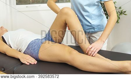 A Modern Rehabilitation Physiotherapist At Work With Client. Working On Shoulder.