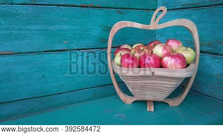 Apples In A Wooden Vase Against The Background Of A Green Wall. Harvest Apples In The Village. Baske