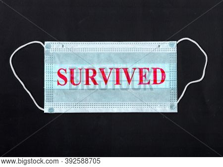 Protective Medical Face Mask. Survived Has Written On Non-permanent Mask. Medical Mask Isolated On B