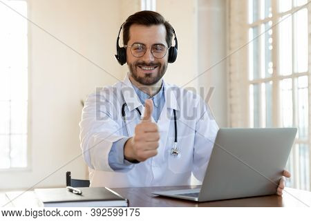 Happy Doctor In Wireless Earphones Recommending Contact To Medical Hotline