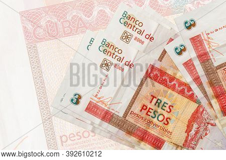 3 Cuban Pesos Convertibles Bills Lies In Stack On Background Of Big Semi-transparent Banknote. Abstr