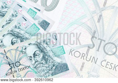 100 Czech Korun Bills Lies In Stack On Background Of Big Semi-transparent Banknote. Abstract Busines