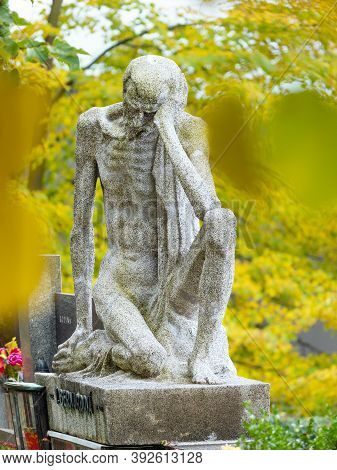 Skinny Old Man, Male Granite Statue Sitting On A Tombstone. 24th Of October 2020. Hronov, Czechia. O